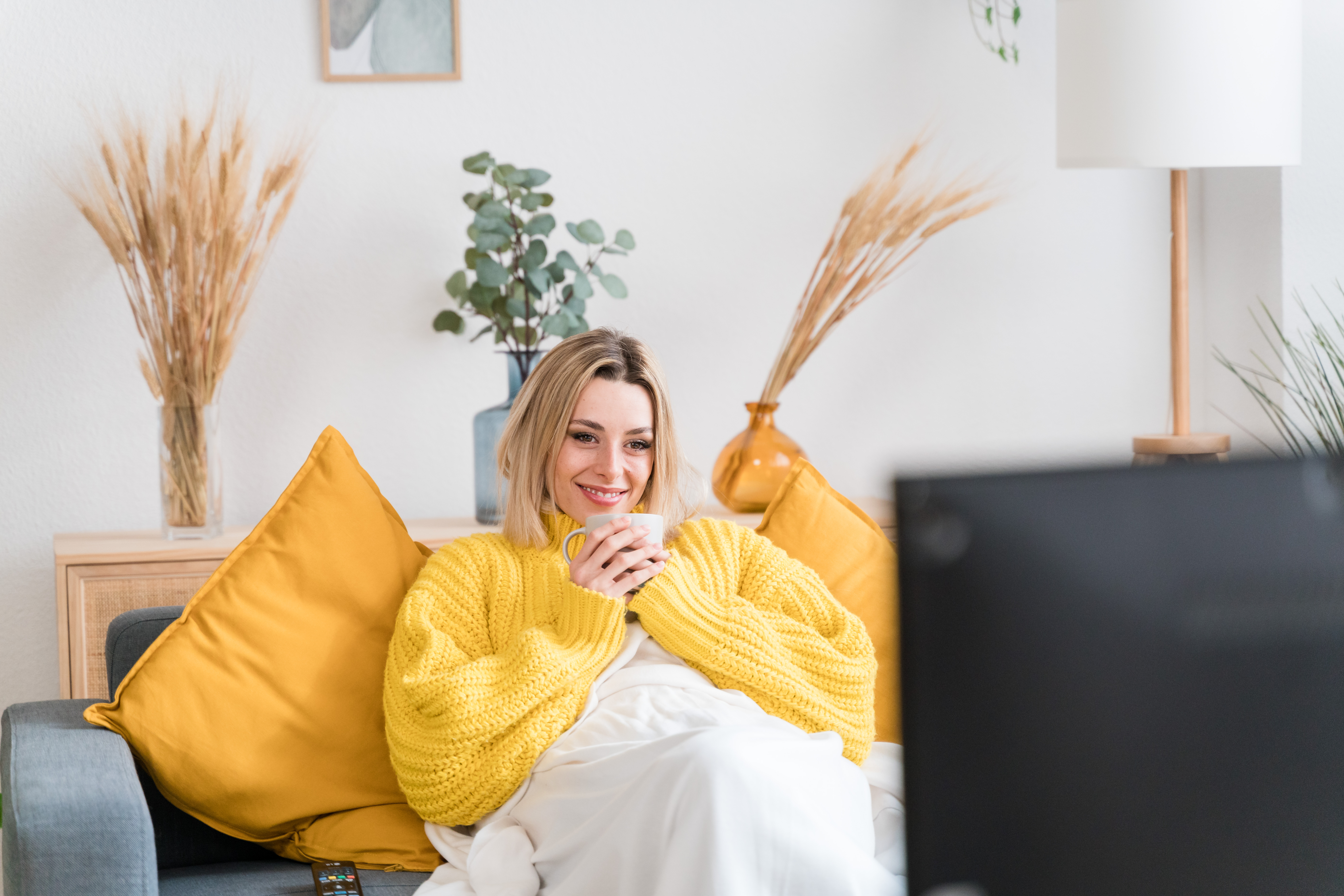 Happy woman watching tv warm at home